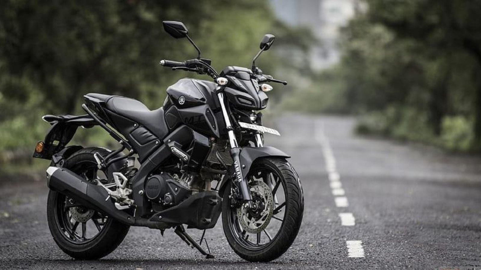 Black Yamaha motorcycle displayed on an open road, showcasing modern design and performance at Alagendran Autos bike showroom in Madurai.